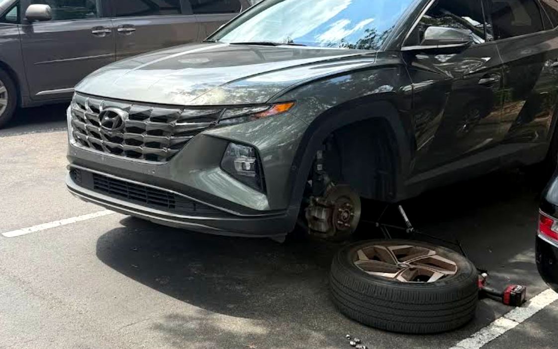 Mobile mechanic replacing brakes on an SUV in a Tampa parking lot